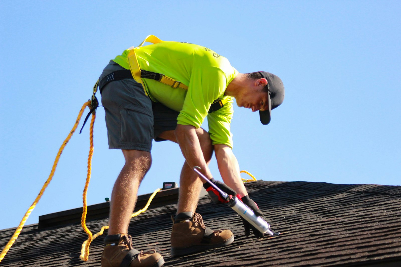 Installer sealing a roof penetration point during a solar install